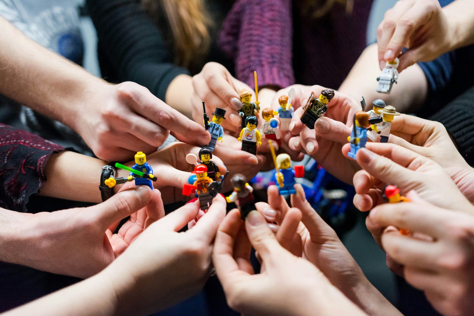 Hands holding figures in a circle, representing the studio's team